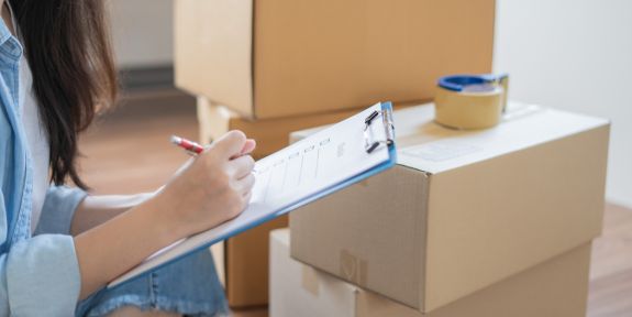 Girl is signing a checklist before moving with the Moving Company